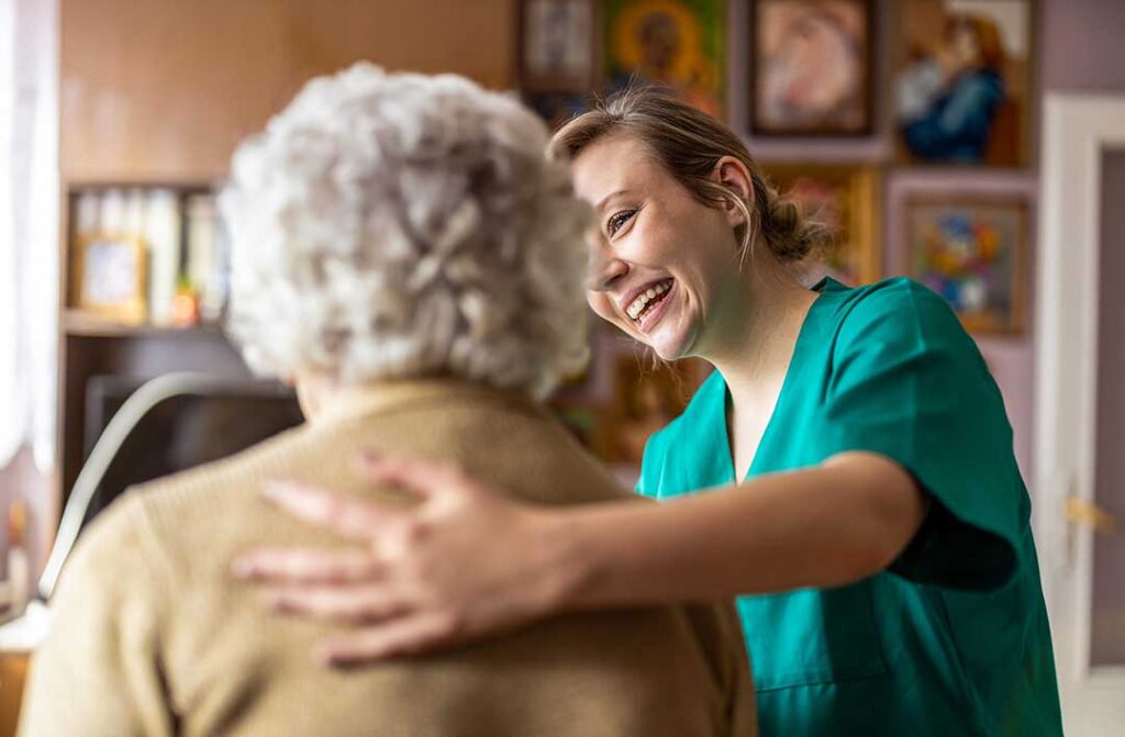 Three older adults sitting together in a cozy living room, engaged in friendly conversation and smiling.