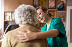 Three older adults sitting together in a cozy living room, engaged in friendly conversation and smiling.