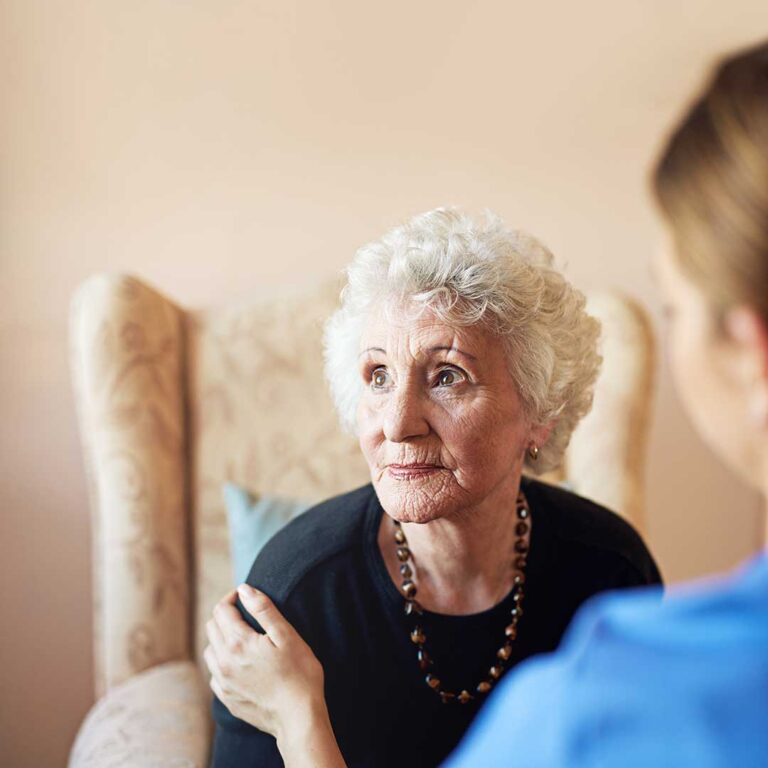 Older adults seated in a bright common room during a guided music and relaxation activity.