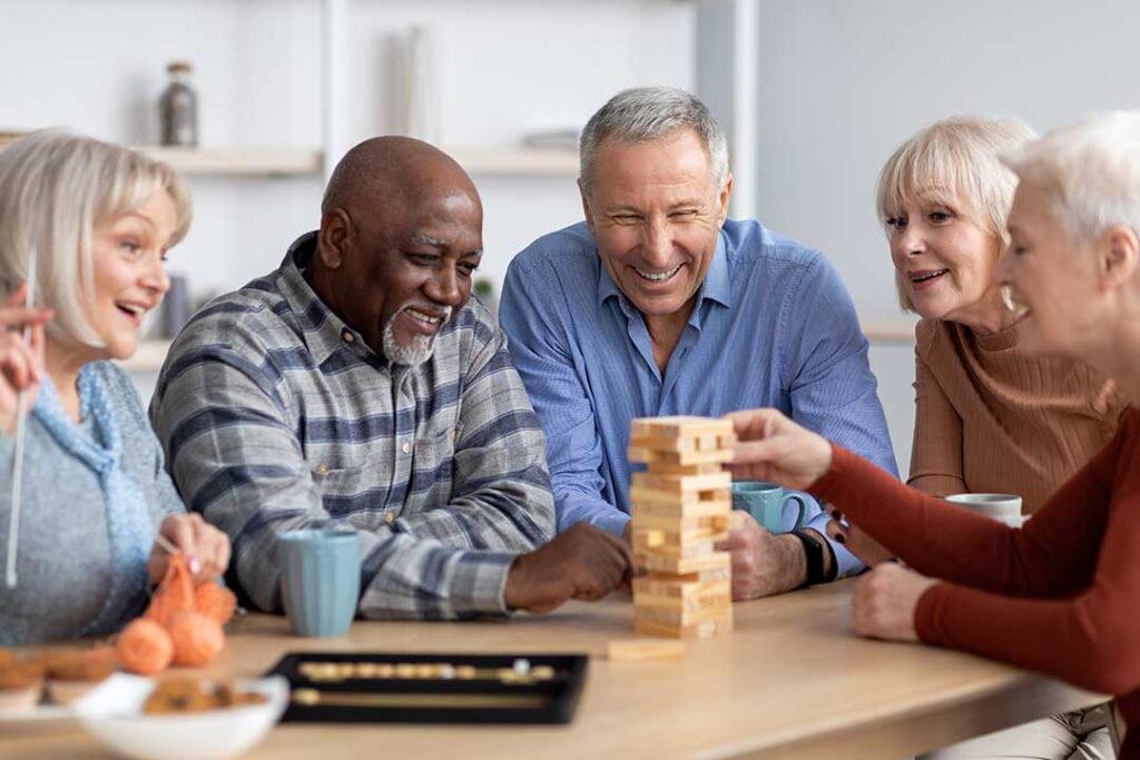 Older adults share a balanced meal with vegetables, protein, whole grains, and water in a bright dining room.